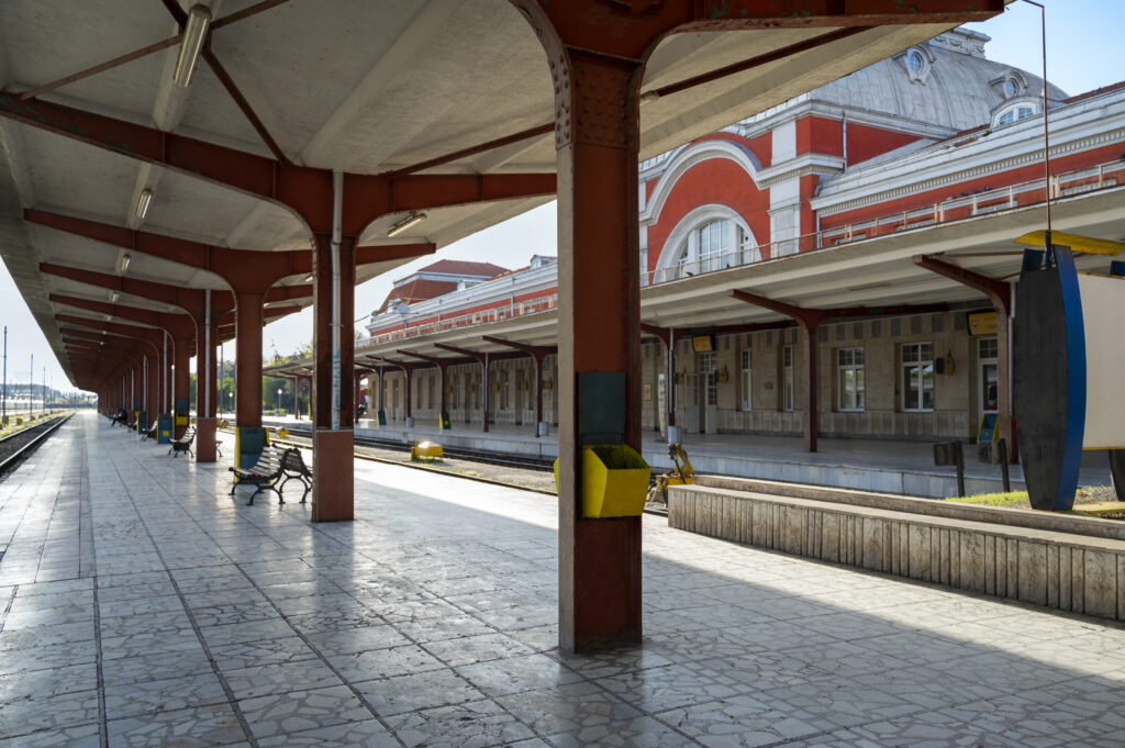 Historic train station platform with a covered canopy, red brick building, and benches in a Monmouth County, NJ commuter town on the NJ Transit North Jersey Coast Line