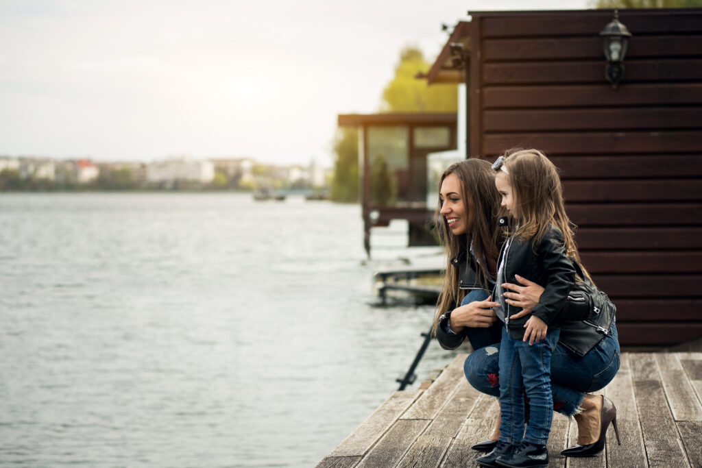Mother and daughter enjoying the view from a wooden dock by the water