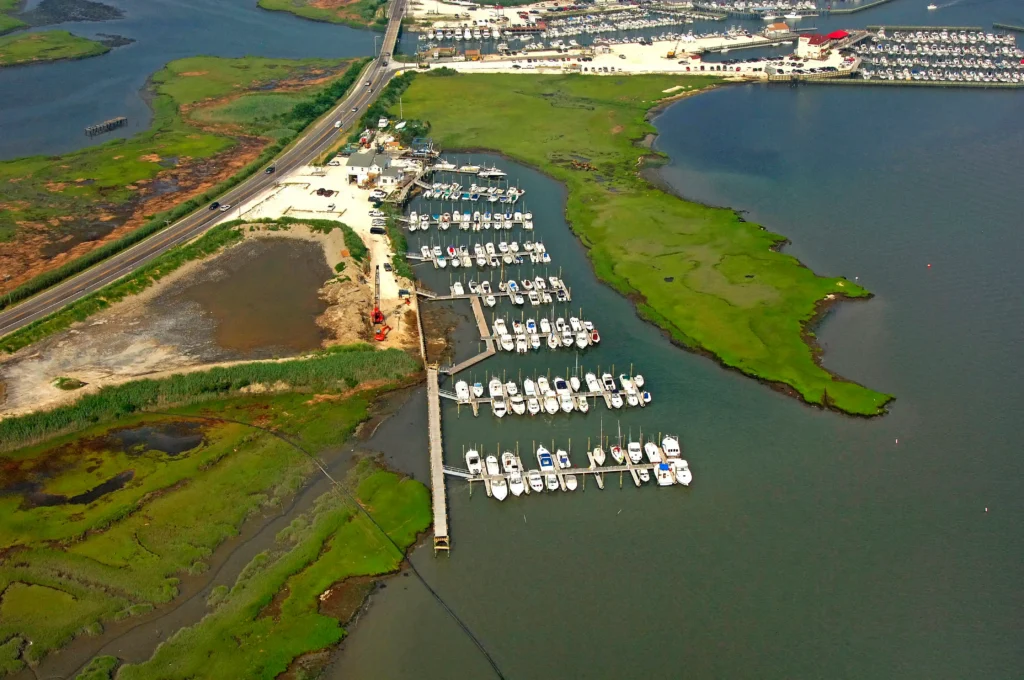 Aerial view of a marina and boat slips along the tidal waterways and salt marshes of Toms River Township, Ocean County, NJ, surrounded by lush green wetlands